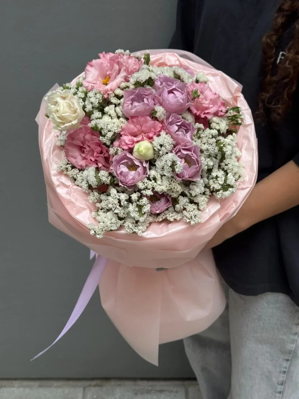 A mixed bouquet of Lavender Bubbles spray roses, pink lisianthus, and white statice.