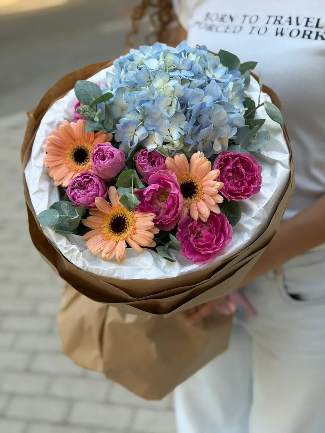 Mixed bouquet of blue hydrangeas, Misty Bubbles spray roses, and peach gerberas